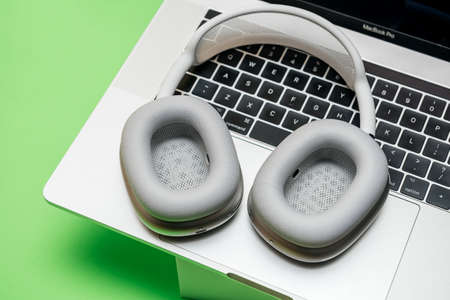 Paris, France - Jan 7, 2021: Close-up of ear cup vent on AirPods Max wireless Bluetooth over-ear headphones created by Apple Computers on the keyboard of MacBook Pro laptop with silicon M1 chipのeditorial素材