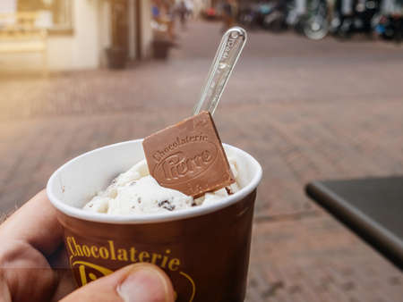POV male hand holding icecream from the Chocolaterie Pierre in central Haarlemのeditorial素材