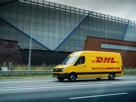 Side view of fast driving DHS fast delivery Volkswagen van on the Dutch highwayのeditorial素材
