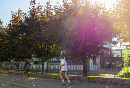 Senior male running on the empty city street with offices building in background