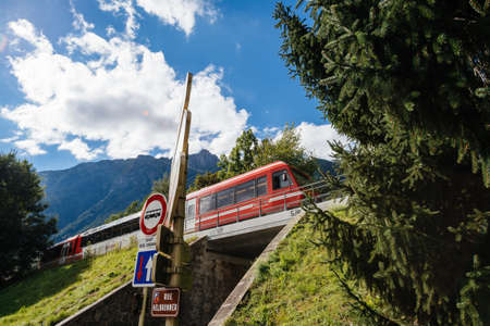Red train with destination Mer De Glace above Rue Helbronnerのeditorial素材