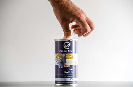 male hand opening Campo Verde Dinkel Kaffee bio coffee product by Demeterのeditorial素材