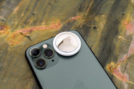 New AirTag above avove iPhone 12 Pro focus on Ultra Wideband engraving