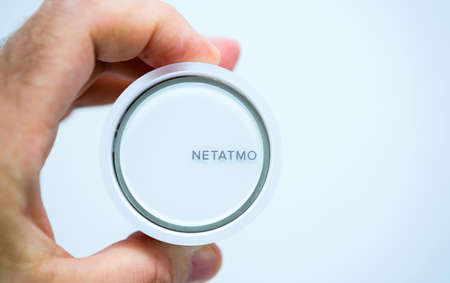 POV male hand holding Netatmo by Stark intelligent radiator thermostatic headのeditorial素材