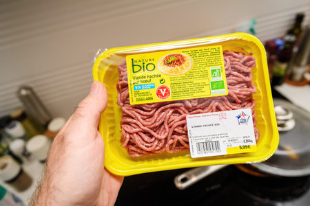 Man hand holding in kitchen package with Nature Bio organic minced beef meatのeditorial素材