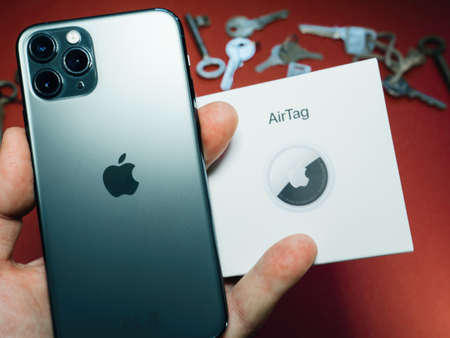 an pov holding package with AirTag and iphone with multiple keys in backgroundのeditorial素材