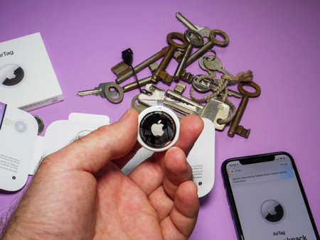 Man pov holding new AirTag and iphone with multiple keys in backgroundのeditorial素材