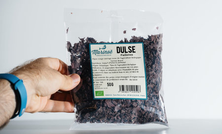 POV male hand holding package with Marinoe dried Dulse Palmaria Palmataのeditorial素材