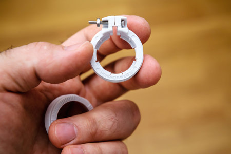 POV close-up male hand holding new Netatmo valve adapter for connected radiator
