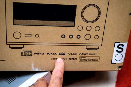 POV male hand holding new package for mini hi-fi component audi system