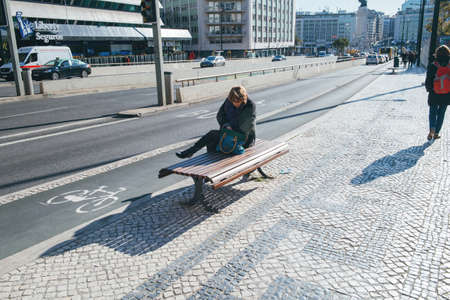 Woman resting on publick bench in central Lisbon on a warm winter dayのeditorial素材