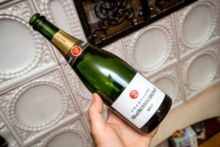 Man holding new empty bottle of Alfred Rothschild and Company champagne bottle with luxury oven in backgroundのeditorial素材