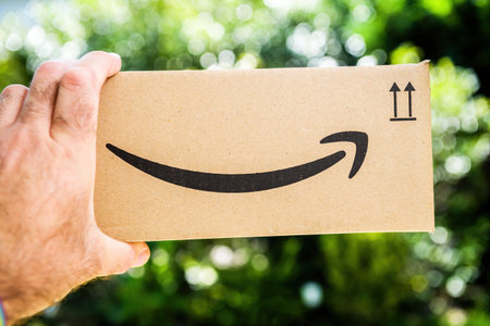 POV personal perspective male hand holding Amazon prime cardboard packageのeditorial素材