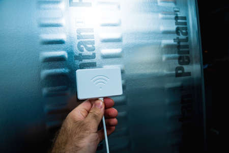 POV male hand holding new Wifi dongle for Home-Connect refrigerators manufactured by Bosch and Siemensのeditorial素材