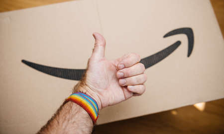 approving hand sign wearing a gay bracelet with Amazon prime cardboard in backgroundのeditorial素材