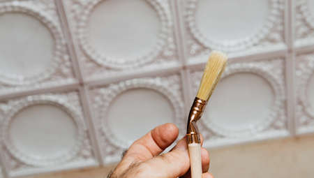 Male hand holding new natural paintbrush for house home decorationの写真素材