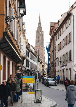 People pedestrians walking on Rue des Juifs in city center with Notre-Dame de Strasbourgのeditorial素材