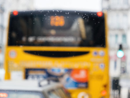 rainy windshield at a large defocused yellow public transportation busの写真素材