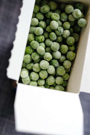 Close-up macro shot frozen peas in cardboard carton boxの写真素材