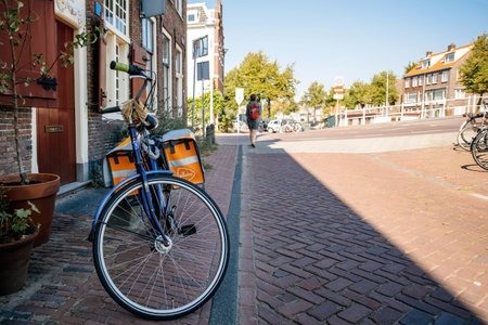 Peugeot bike with PostNL postal bike carriage parked on the cobblestone roadのeditorial素材