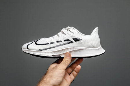 Pov male hand holding new luxury running shoes Nike Zoom react in mans handのeditorial素材