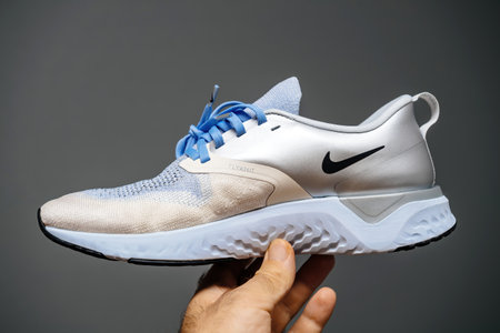Pov male hand holding new luxury running shoes Nike Flyknit reactのeditorial素材