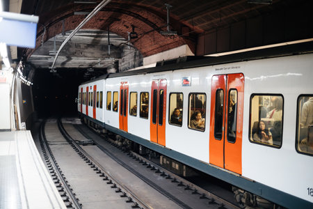 Barcelona Underground metro station with people inside train reading using smartphones listening to musicのeditorial素材