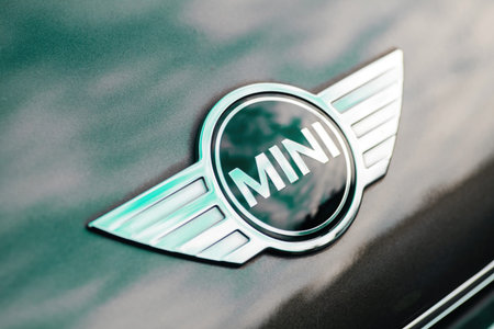 Close-up of Mini Cooper car logotype on the green metallic car hood