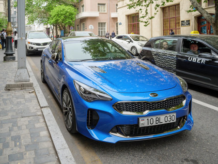 Blue colored Kia Stinger sports car parked on Baku street with Uber taxiのeditorial素材