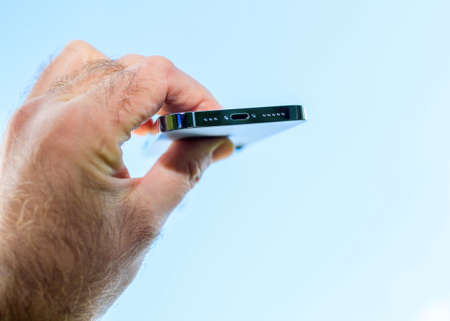 Male hand holding latest Apple Computers iPhone 13 pro with lighting connector charging portのeditorial素材