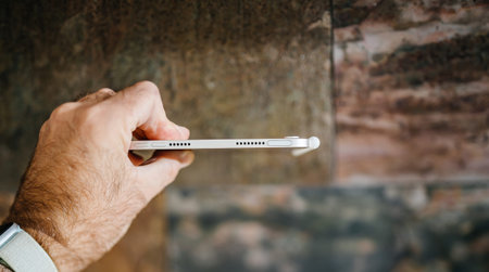 POV male hand holding thin Apple Computers new iPad Mini 6th tablet with Apple pencilのeditorial素材