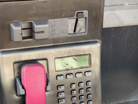Close-up of Deutsche Telecom phone booth with old operated phone with coins or card - public communicationのeditorial素材
