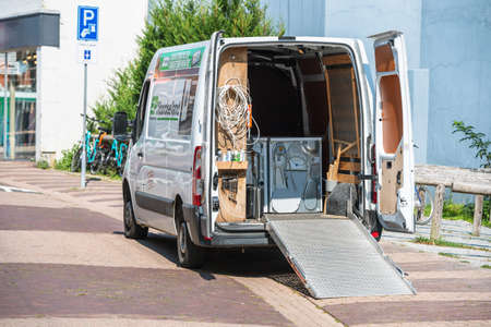 White electric Volkswagen transporter van transporting wash dryer and washing machines - large home appliance installation transportation renovationのeditorial素材