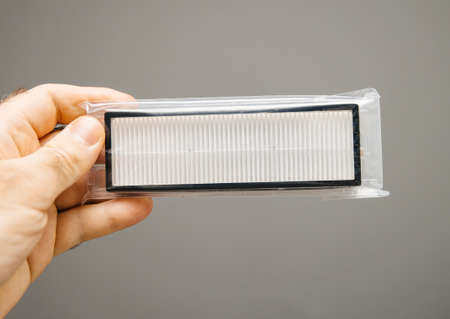holding the small hepa fipter fir the new robot vacuum cleanerの写真素材
