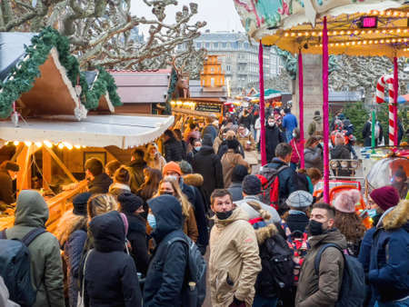 Crowd of people attenting wearing safety respiratory face mask near market stalls chaletsのeditorial素材