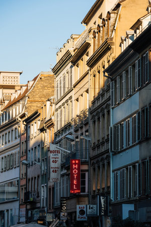 Multiple hotel signage on the facade of tall haussmannian apartment buildings
