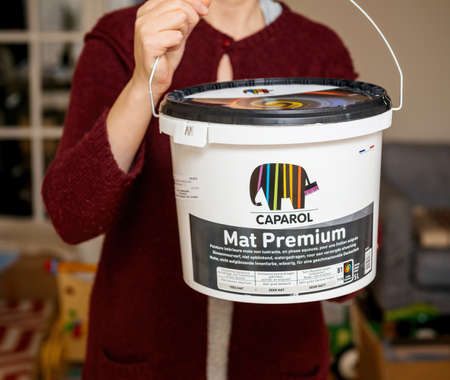 Young woman holding new plastic package of Caparol Mat Premium luxury German paintのeditorial素材