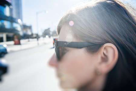 Side view of young beautiful woman wearing luxury American Maui Jim sunglassesのeditorial素材