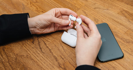 Woman holding after unboxing pair of new AirPods Pro wireless Bluetooth in-ear headphones