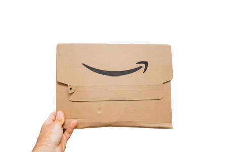 Pov male hand holding new package of Amazon Prime cardboard packageのeditorial素材