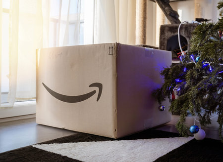 Amazon Prime type on cardboard parcel box next to Christmas tree in house