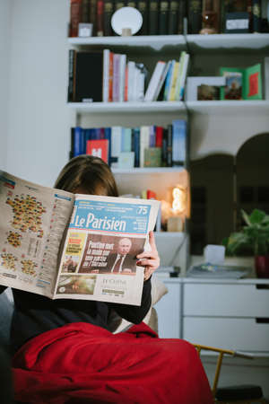 Woman reading French newspaper Le Parisien with headlines Russian president Vladimir Putinのeditorial素材