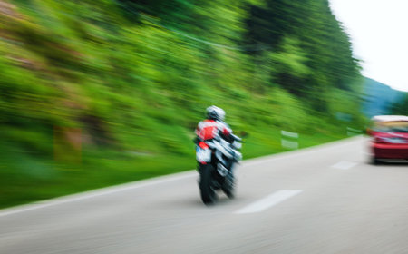 Rear view of defocused unrecognizable motorcyclist sign on German highwayの写真素材