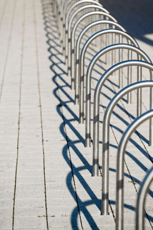 Multiple stainless steel secured empty bike stand vacant racks designed to park bicyclesの写真素材