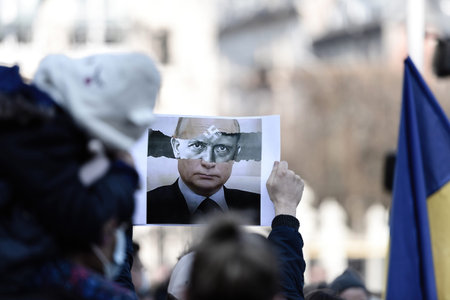 Vladimir Putin compared to Adof Hitler on placard in male hands at protest in front of Russian...