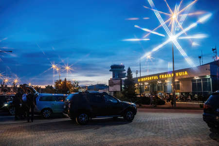 Main facade at dusk of Timisoara International Airport Traian Vuia with cars passengers ready to departのeditorial素材