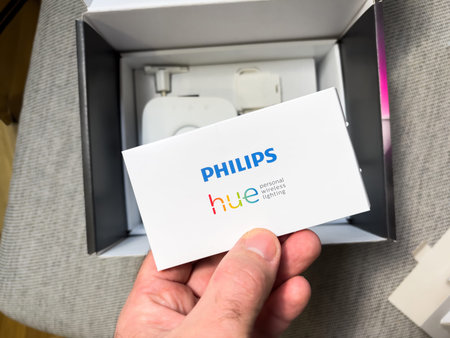 POV male hand holding Philips hue instruction manual after unboxing - a line of color changing LED...