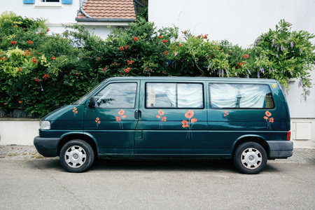 Green Volkswagen van parked on a city street decorated with flower stickersのeditorial素材