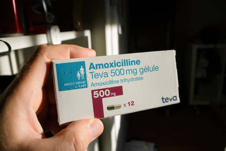 POV male hand holding package with Amoxicilline manufactured by TEVA laboratories.のeditorial素材