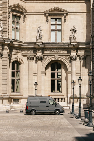 Gray van with Louvre inscription parked somewhere on a Paris street near beautiful architecture buildingのeditorial素材
